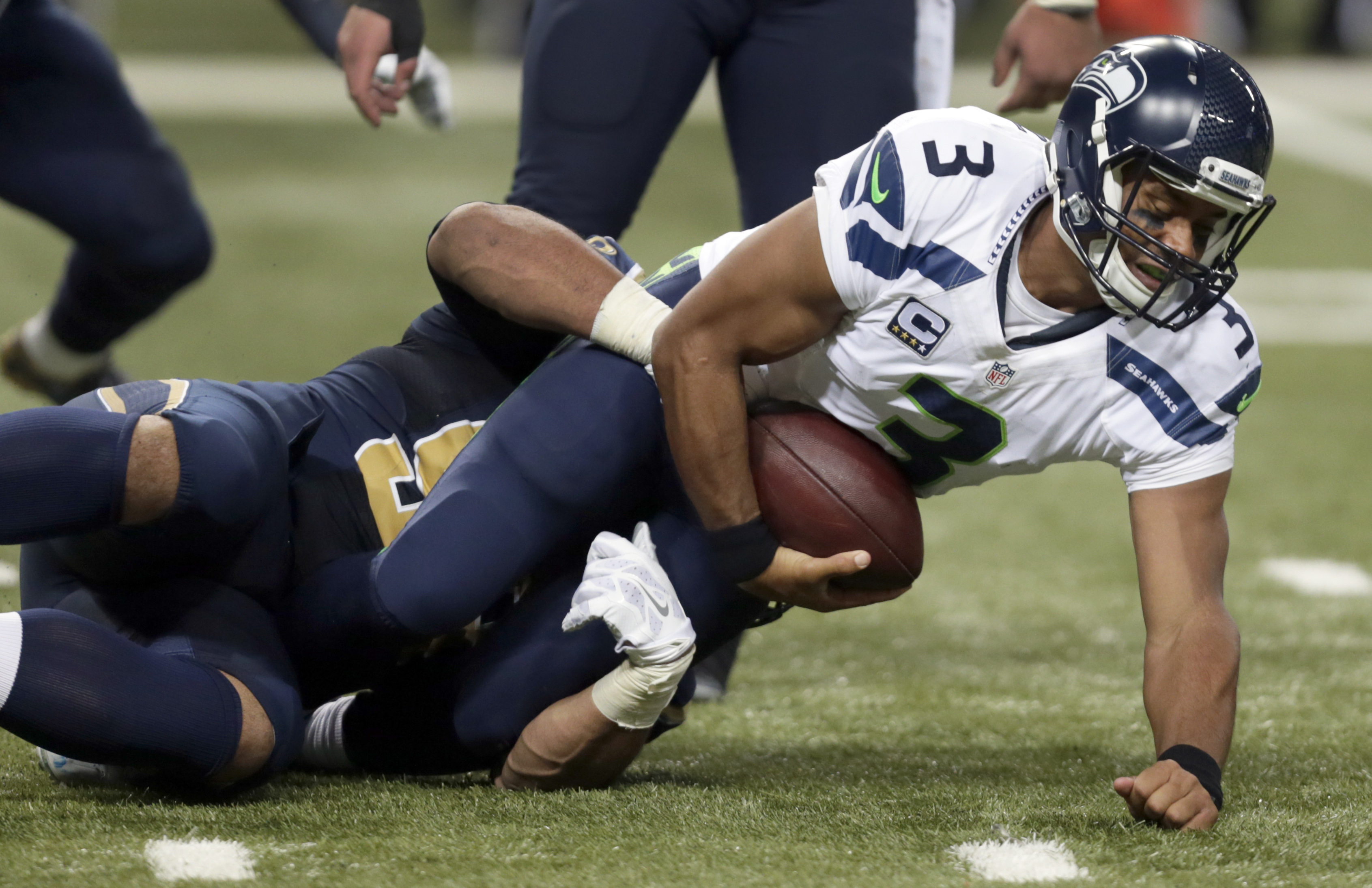 Seattle Seahawks quarterback Russell Wilson, right, is sacked for a 4-yard loss by St. Louis Rams defensive tackle Aaron Donald during the third quarter of an NFL football game Sunday, Sept. 13, 2015, in St. Louis. (AP Photo/Tom Gannam)